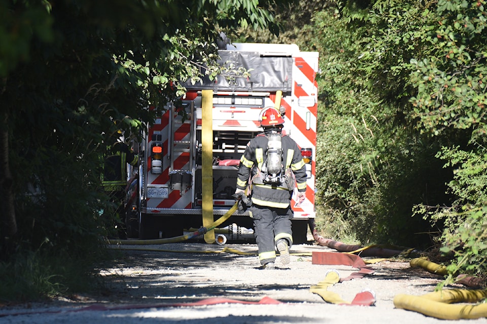 Firefighters from Port Alberni, Beaver Creek, Cherry Creek and Sproat Lake fire departments set up down a long driveway in the 5200-block of Josephine Street, where smoke from a structure fire could be seen from all over Port Alberni on July 16, 2024.