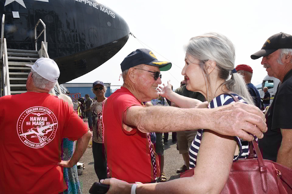 Martin Mars waterbomber pilot John de Bourcier, centre, greets former waterbomber dispatcher Lori Behnke at a public 'farewell to the Martin Mars' Saturday, July 27, 2024 at the Sproat Lake Bomber Base. 