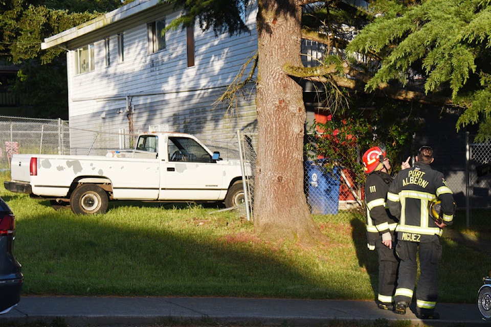 Firefighters with Port Alberni Fire Department wait for a tow truck after assessing the structural integrity of a two-storey house after a pickup truck left the road on Fifth Avenue and collided with the house Sunday evening, June 9, 2024. 