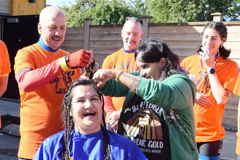 Tour de Rock rider Chris Baratto and former junior rider Kayla Aolick cut Betty Harrigan's braids at the 10th Avenue Co-op on Friday, Sept. 27.
