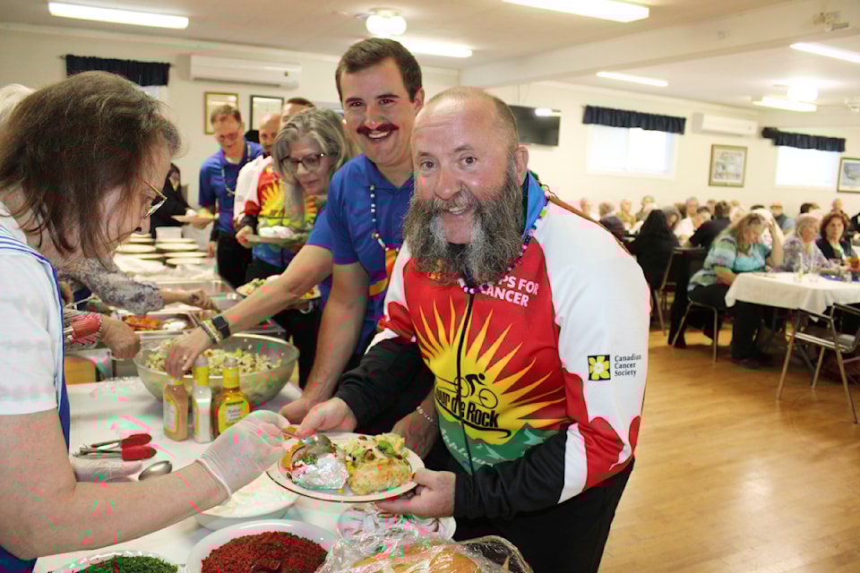 Warren Kongus goes in for some food at the Royal Canadian Legion Br. 293 before having his mutton chops trimmed down by junior rider Ryker Dodding. 