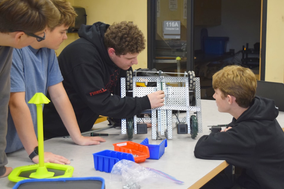 Students with the ADSS Robotics Club work on a pair of robots that will compete in the upcoming tournament.