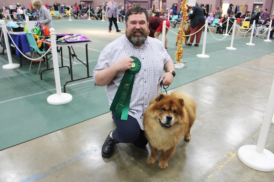 An elated Travis Mercer poses for a photo with his Chow Chow, Otis, who took best overall on Saturday.