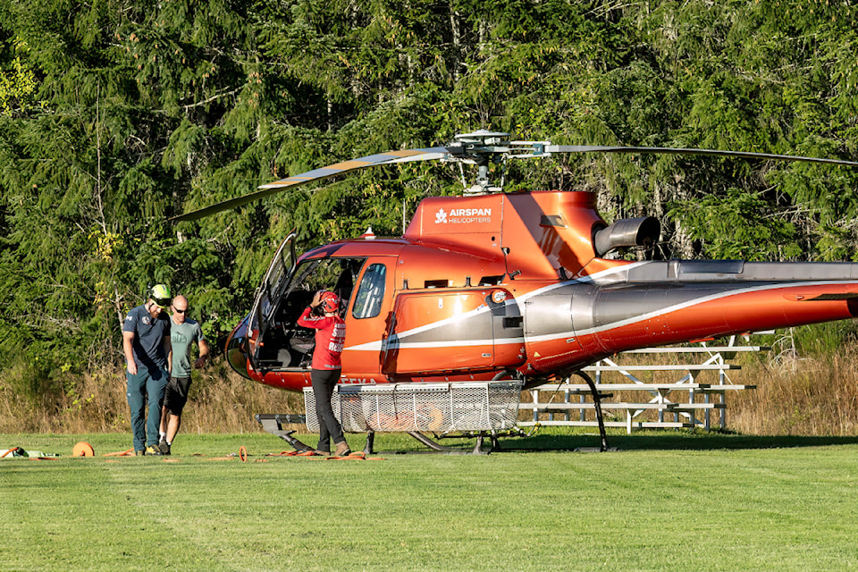Volunteers with Alberni Valley Rescue Squad and Arrowsmith Search and Rescue work with an Airspan Helicopters pilot to set up a long line in a field behind the rugby club at the top of Argyle Street on Friday, Aug. 30, 2024. 