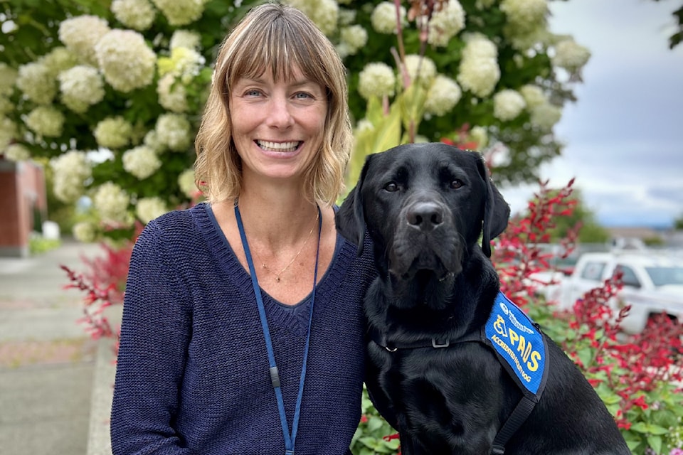 Tamara Cocco, manager of Police Victim Services in Port Alberni, sits with Milo, the newest member of the team. Coco is Milo's Pacific Assistance Dogs Society (PADS) handler. 