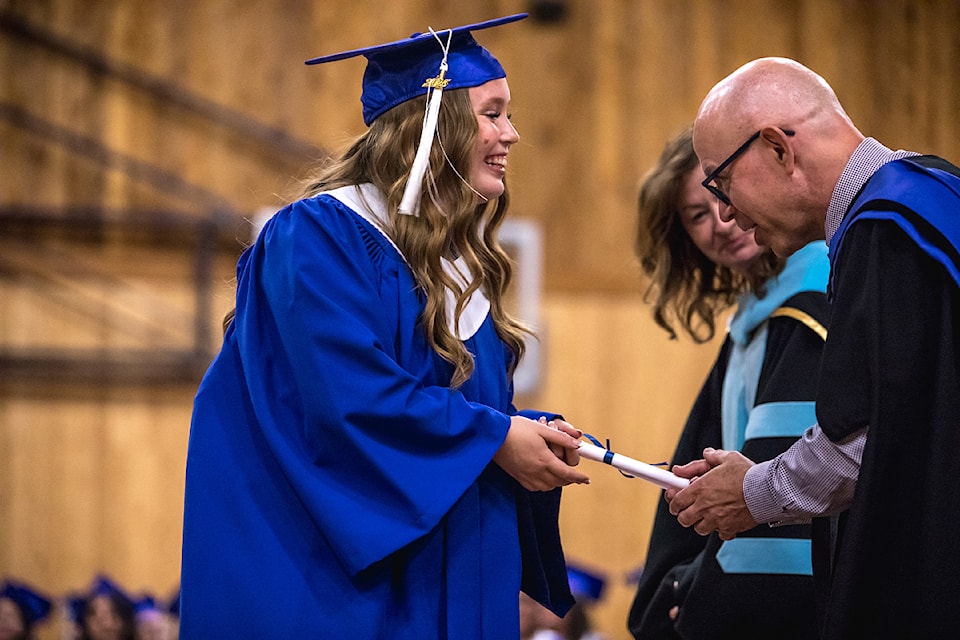 An NIC graduate grins as vice-president, academic, Tony Bellavia presents her certificate during graduation ceremonies June 12, 2025 at the Alberni Athletic Hall. (LYNDON CASSELL/ Alberni Valley News)