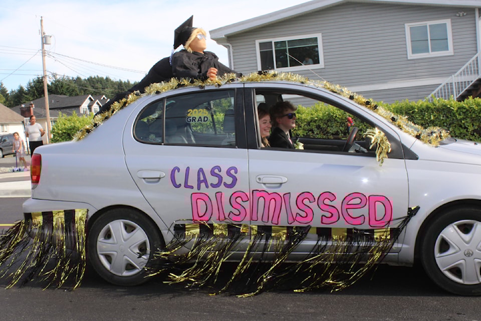 Kass Stirzaker, behind the wheel, and Madison Gamble have a stowaway on the roof of their car as they begin the annual ADSS grad car parade on Burde Street, Saturday, June 21, 2025. (SUSIE QUINN/ Alberni Valley News) 