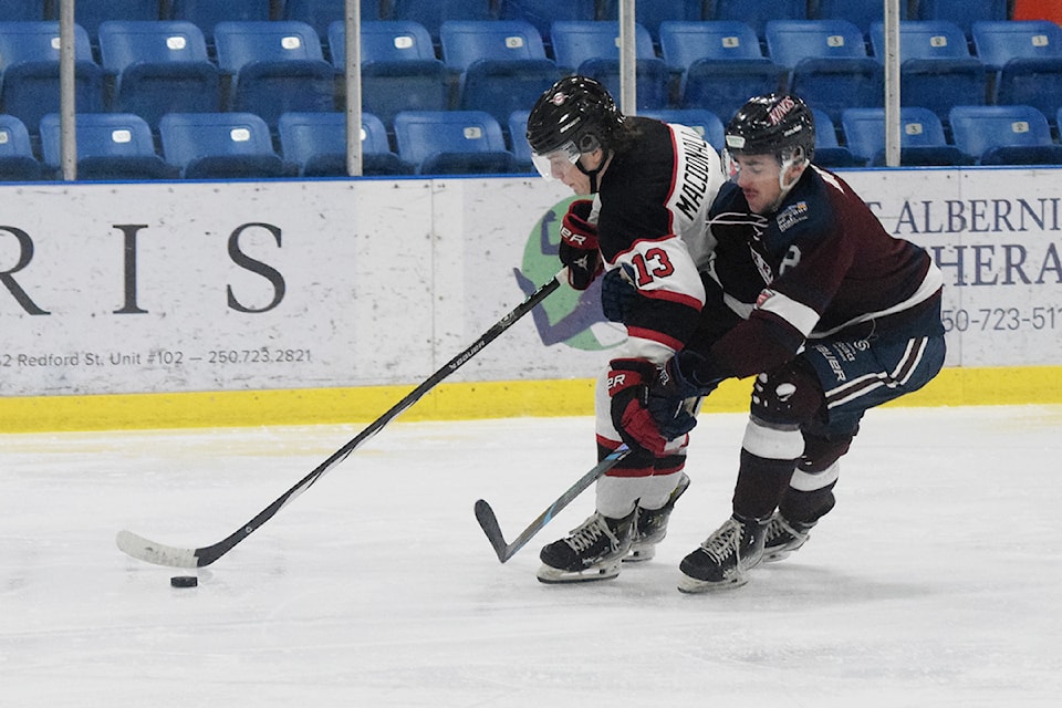 Bostyn MacDonald of the Port Alberni Bombers and Gavin Mowat of the Comox Valley Glacier Kings grapple for the puck.