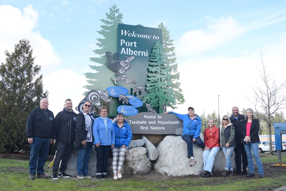 Port Alberni city councillors, artists and representatives from Hupacasath and Tseshaht First Nation pose beside the newly-installed "Welcome to Port Alberni" sign.