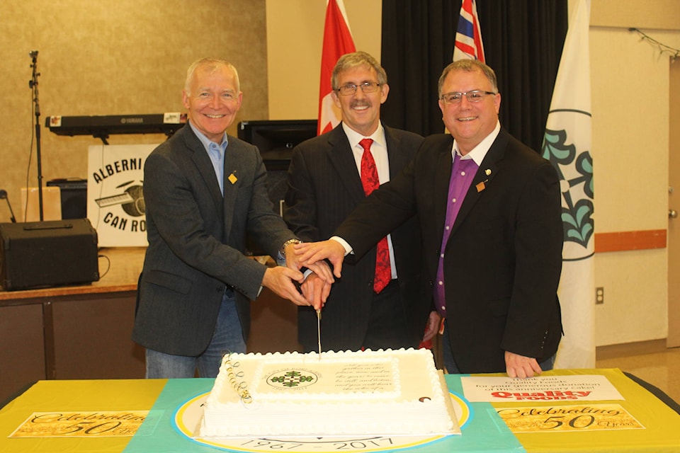 SONJA DRINKWATER PHOTO Mid Island-Pacific Rim MLA Scott Fraser, Port Alberni mayor Mike Ruttan and Courtenay-Alberni MP Gord Johns cut a special cake (donated by Quality Foods) to celebrate the 50th anniversary of the city’s amalgamation.