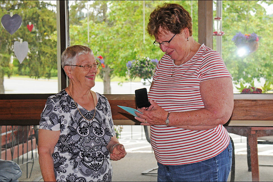 Doreen Bessette accepts a card and necklace from Marlene Dietrich of Abbeyfield House prior to Canada Day celebrations at the seniors’ housing complex. Bessette, a founder, retired from the Abbeyfield board. (SUSAN QUINN/ Alberni Valley News)
