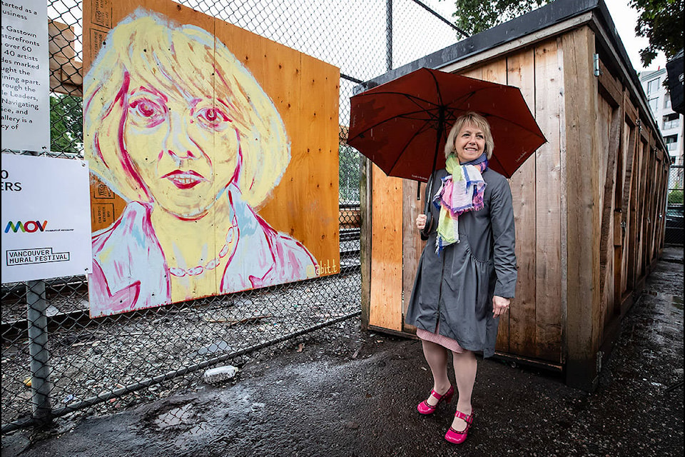 British Columbia provincial health officer Dr. Bonnie Henry wears a pair John Fluevog shoes designed in her honour, as she views her image at the Murals of Gratitude exhibition in Vancouver, on Friday, July 3, 2020. The business improvement association in Vancouver’s Gastown neighbourhood honoured Dr. Henry on Friday with a sneak peek at a mural exhibition featuring her image. THE CANADIAN PRESS/Darryl Dyck