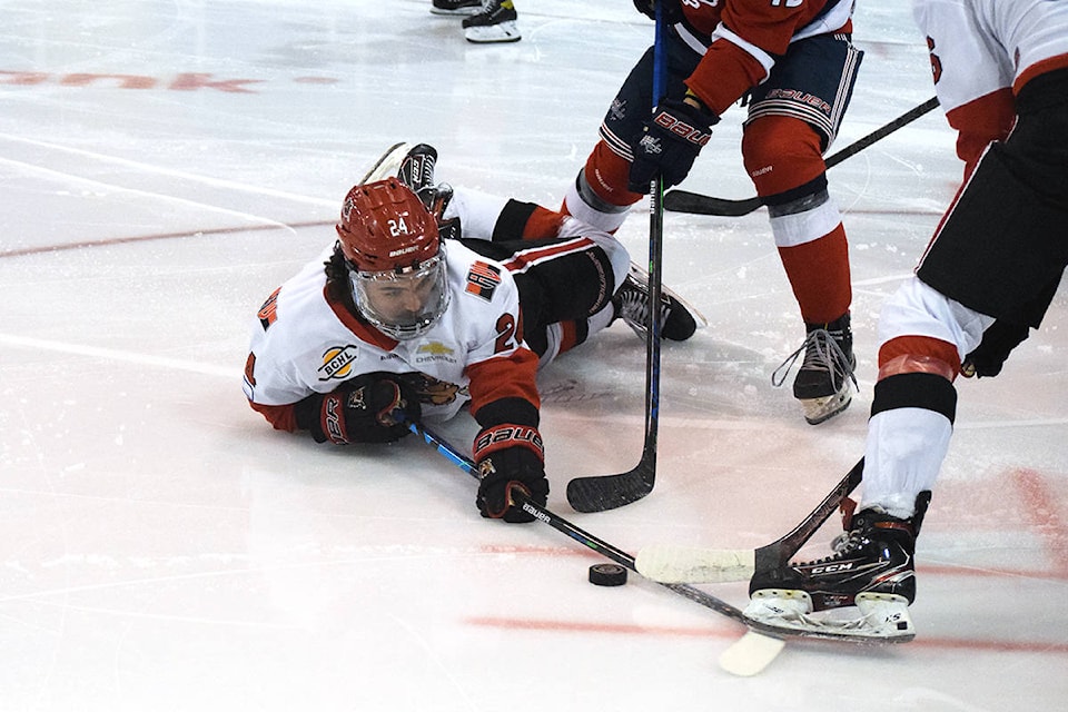 Alberni Valley Bulldogs forward Kobe Assam battles for the puck despite being knocked to the ice during a physical first period against the Cowichan Valley Capitals on April 7. (ELENA RARDON / ALBERNI VALLEY NEWS)