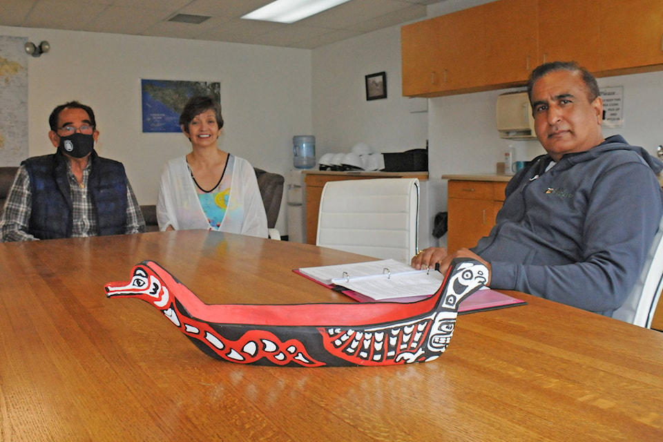 Annie Watts, centre, and her father Tom present San Group owner Kamal Sanghera with a carving of a Tseshaht First Nation canoe. Annie Watts gave the company a carving as thanks for a donation of red cedar blocks. (SUSAN QUINN/ Alberni Valley News)