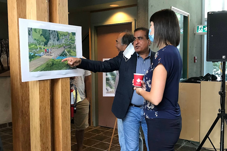 Kamal Sanghera of San Group of Companies discusses the concept behind the billion-dollar Pacific Mayfair Estates with Port Alberni mayor Sharie Minions on Thursday, Aug. 26, 2021. The company announced plans for the housing development in their new Port Alberni headquarters. (SUSAN QUINN/ Alberni Valley News)