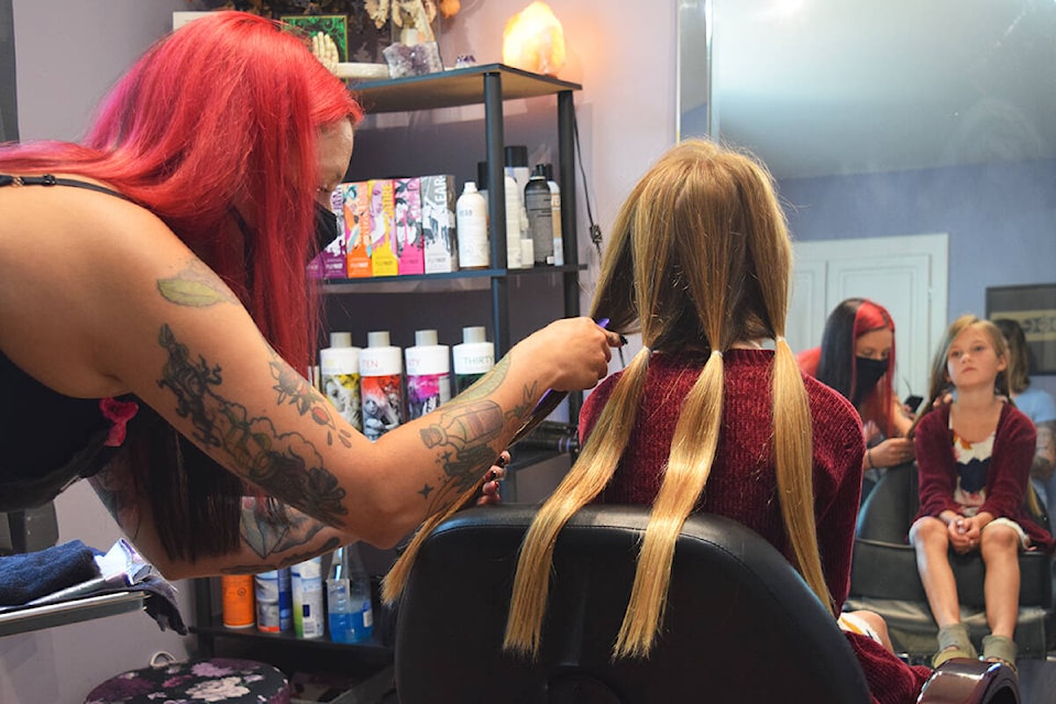 Chantal Lafontaine prepares to cut Taylor Pointon Huth’s hair. (ELENA RARDON / ALBERNI VALLEY NEWS)