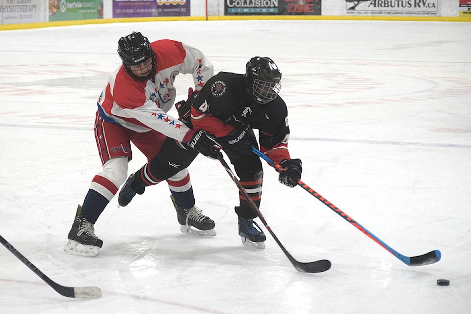 A U18 Bulldogs player keeps the puck away from a Capitals defender during a game on Sunday, Dec. 19. The Bulldogs ended up winning the game 3-2. (ELENA RARDON / ALBERNI VALLEY NEWS)