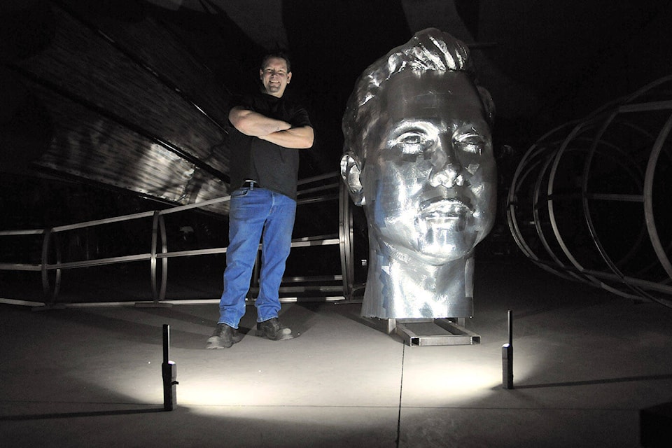 Chilliwack sculptor Kevin Stone stands beside a gigantic Elon Musk head in his workshop on Tuesday, Jan. 18, 2022. (Jenna Hauck/ Chilliwack Progress)