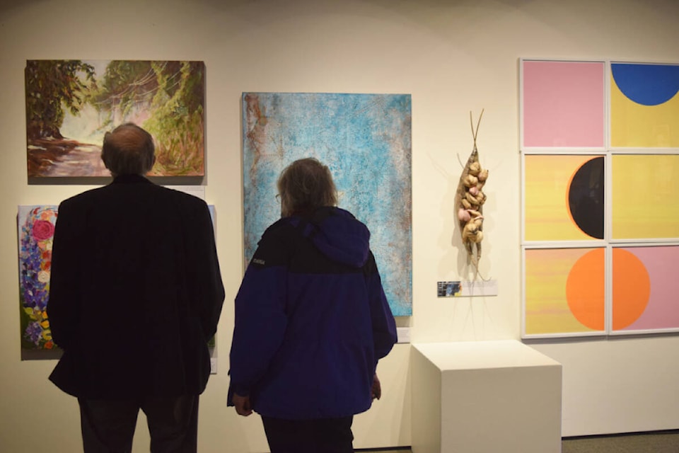 Visitors admire the artwork on display at the Alberni Valley Museum for the newest exhibit, “Emergence: New Works, New Beginnings.” (ELENA RARDON / ALBERNI VALLEY NEWS)