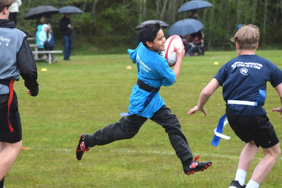 A student from Haahuupayak Elementary School evades opponents during an afterschool rugby game on Wednesday, May 11. (ELENA RARDON / ALBERNI VALLEY NEWS)