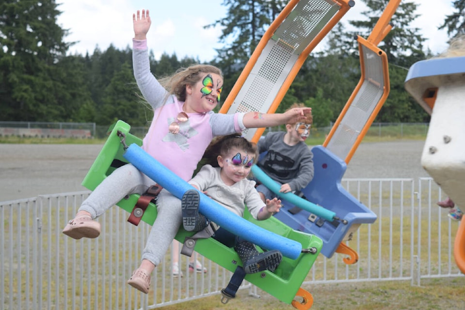 FLYING FUN Jade and Ivy McGregor take a turn on the mobile fun swing amusement ride at the Co-op Members Day outside of the Glenwood Centre on Saturday, June 18. See more from this year’s Alberni District Co-op Members Day on page A7. (ELENA RARDON / ALBERNI VALLEY NEWS)