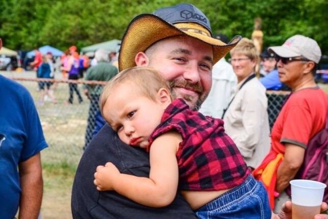 Dustin Riley carries his son Gavin around the 2015 Ukee Days fairgrounds. (Douglas Ludwig photo)