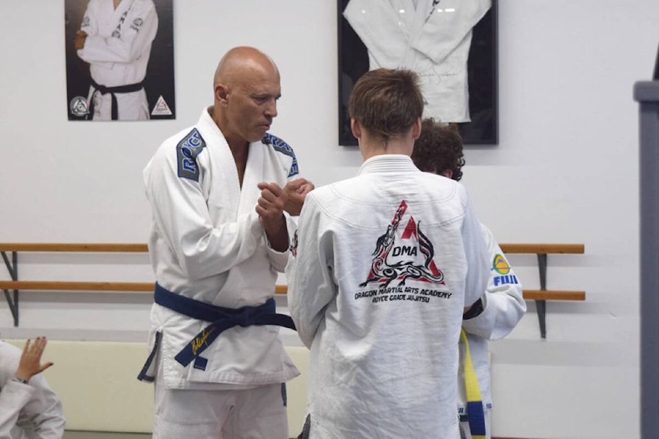 Royce Gracie helps young martial artists practice a move during a workshop at Dragon Martial Arts Academy in Port Alberni on Aug. 21, 2022. (ELENA RARDON / ALBERNI VALLEY NEWS)