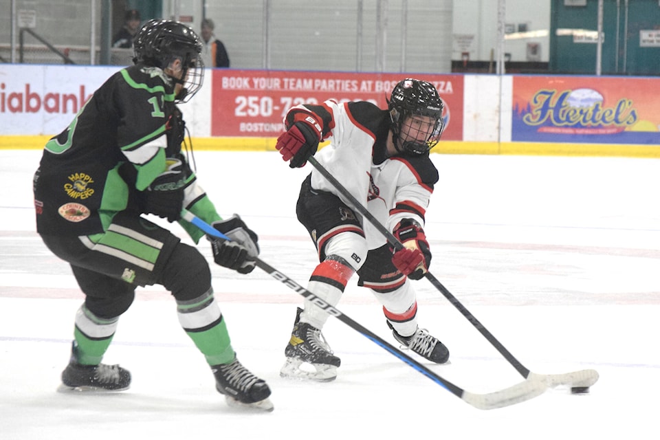 A Port Alberni Bombers player attempts to pass a puck past Lake Cowichan Kraken forward Mitchell Billings during a powerplay opportunity on Wednesday, Sept. 21. (ELENA RARDON / ALBERNI VALLEY NEWS)
