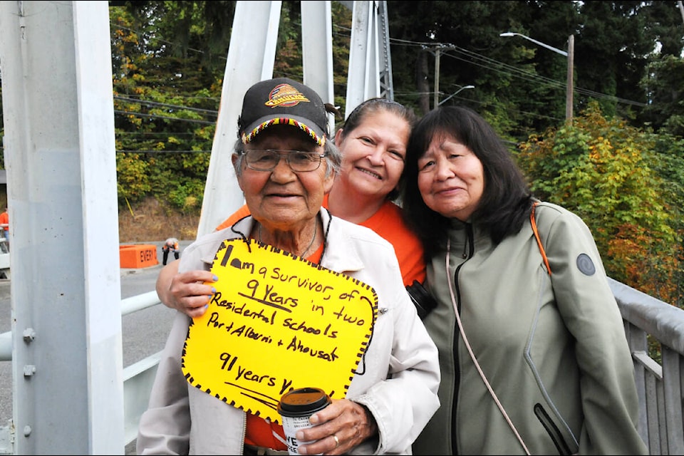Cody Gus, 91, walks across the Orange Bridge near Port Alberni with daughter Gloria Fred and relative Louise Martin on National Truth and Reconciliation Day—a very different experience from the nine years he spent at residential school in Port Alberni and Ahousaht. (SUSAN QUINN/ Alberni Valley News)