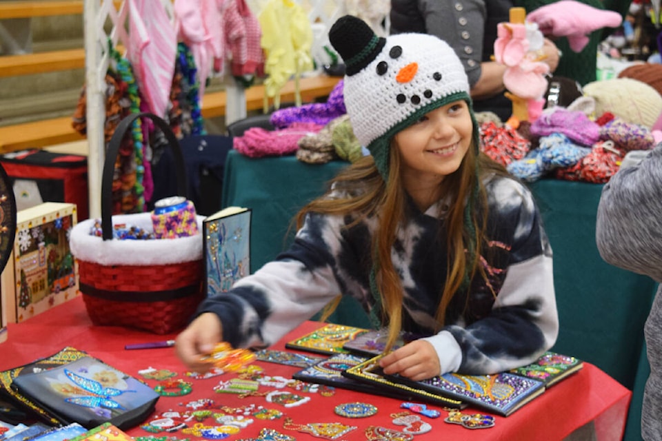 Riley Young shows off some of the ornaments at her table during the Christmas in the Valley craft fair on Saturday, Nov. 12. (ELENA RARDON / ALBERNI VALLEY NEWS)