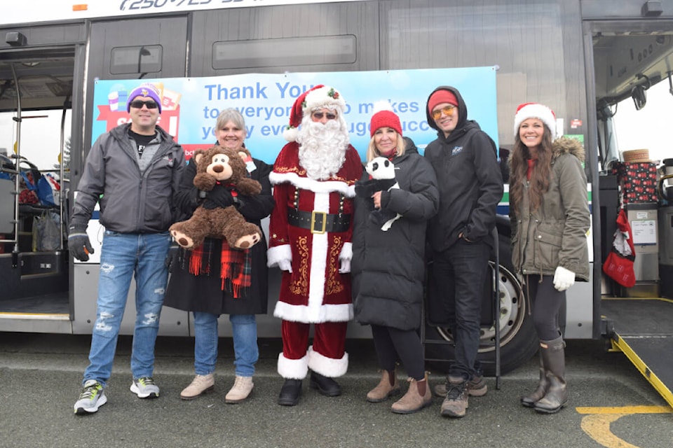 Representatives from Pacific Western Transportation, ATU Local 1747 and 93.3 The PEAK gather for the annual Stuff the Bus campaign in the Walmart parking lot on Saturday, Nov. 26. (ELENA RARDON / ALBERNI VALLEY NEWS)