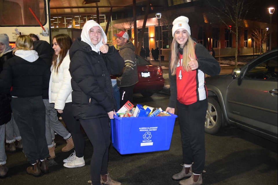 A pair of ADSS students pose for a photo with a bin full of non-perishables during the Athletic Department’s food drive on Monday, Dec. 5. (ELENA RARDON / ALBERNI VALLEY NEWS)