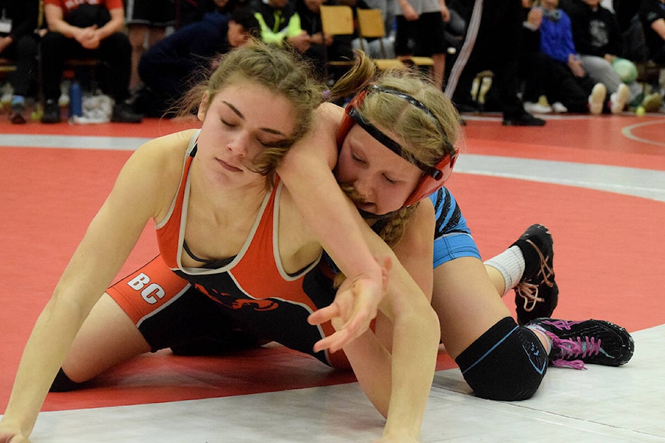 Ucluelet wrestler Olivia Rhodes, in blue, grapples with Maple Ridge’s Maddy Grof during the finals of the Alberni Invitational on Saturday, Feb. 4. Rhodes placed second in the match. (ELENA RARDON / ALBERNI VALLEY NEWS)