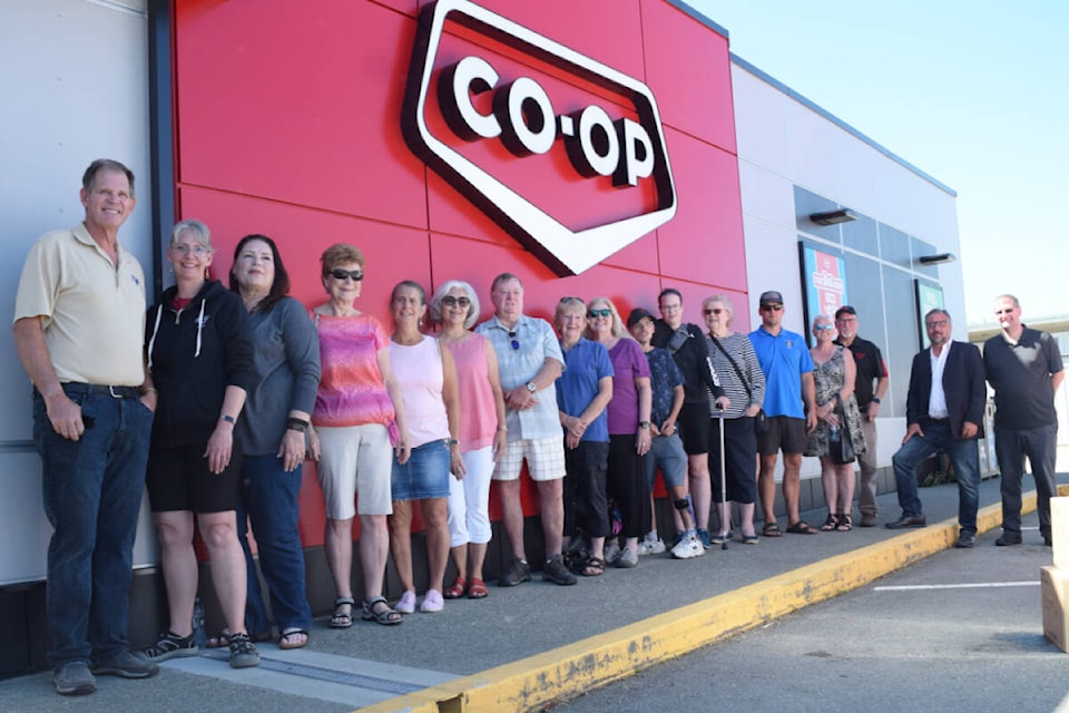 Members of the Alberni District Co-op board of directors and management team gather outside of the Johnston Road Co-op with funding recipients on Wednesday, July 19. (ELENA RARDON / Alberni Valley News)
