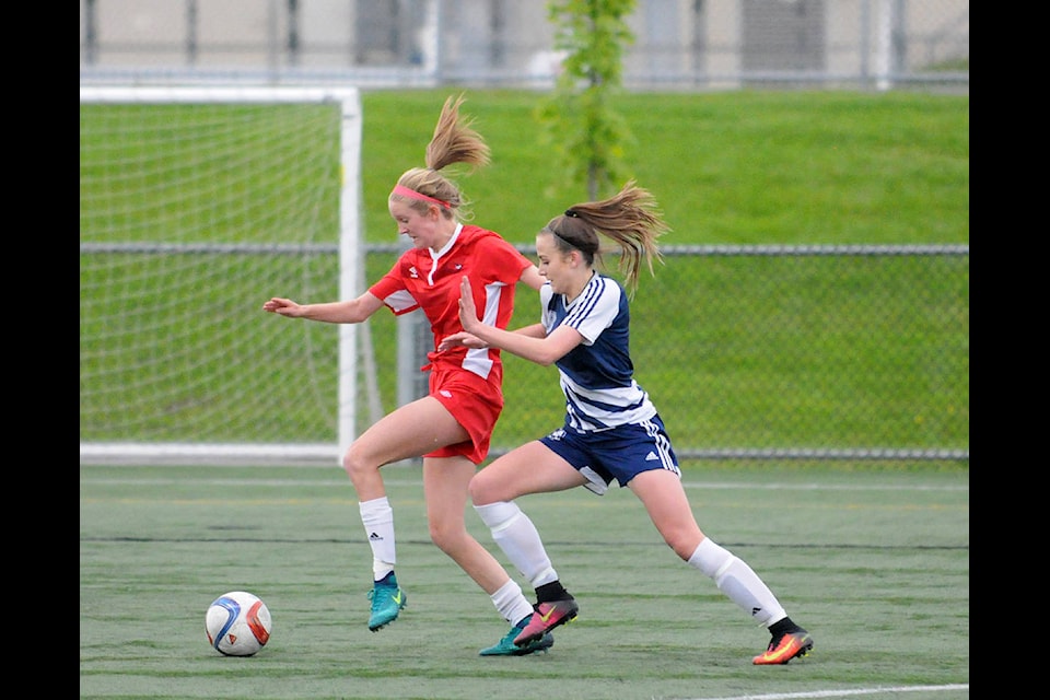 DW Poppy Redhawks’ Emily White and Langley Fundamental Titans’ Makenna Dieterich during Poppy’s 2-0 win the Fraser Valley AA senior girls championship game at Willoughy Community Park on May 17. Gary Ahuja Langley Times