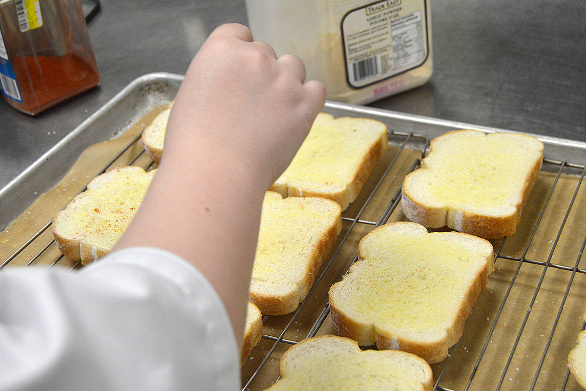 16848991_web1_A-Student-prepares-garlic-bread-for-their-Professional-Cook-1-course