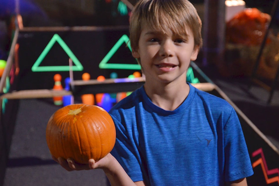 Under special lights, youngsters such as Lucas, bowled pumpkins to knock over glow in the dark bowling pins at the South Ridge Church Pumpkin Fest. (Heather Colpitts/Langley Advance Times)