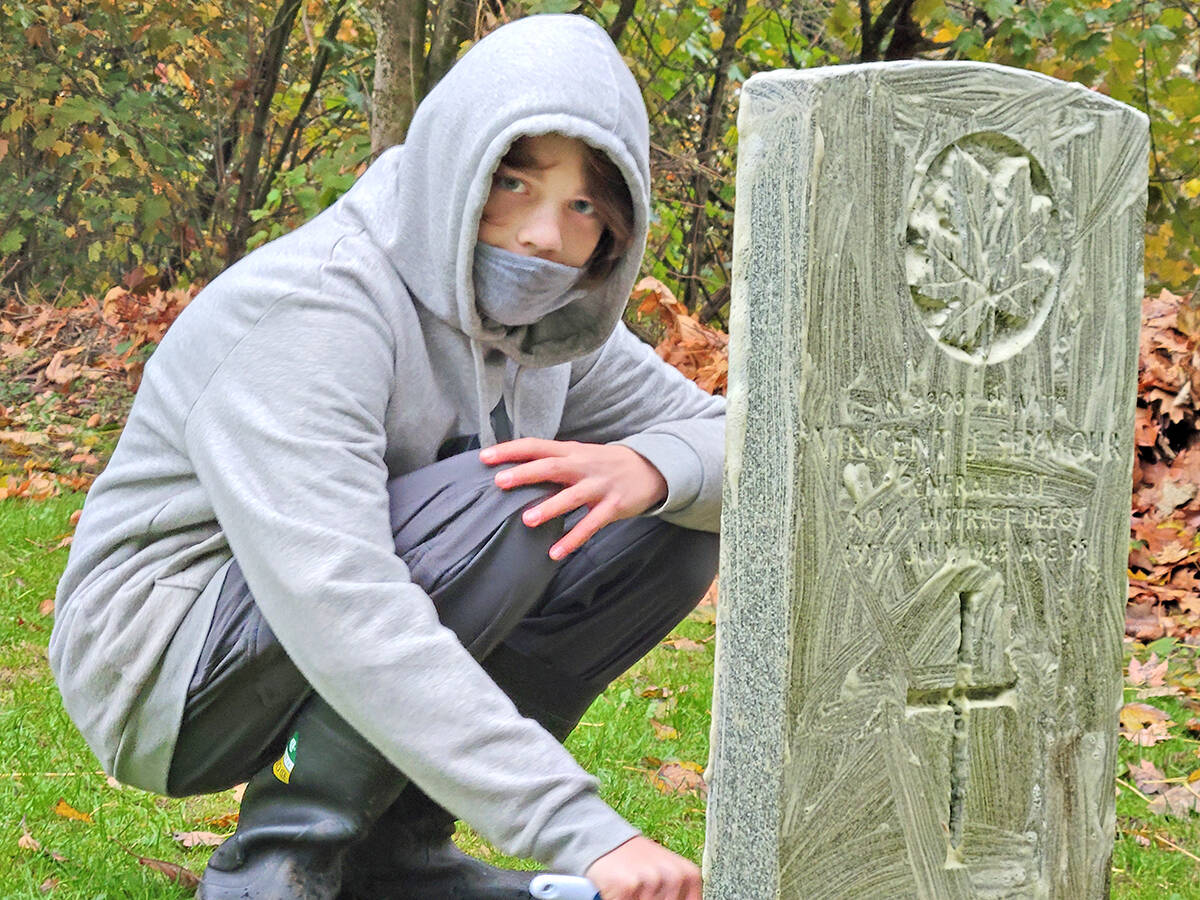 Jordan Worrall works on his great-great uncles headstone. He was one of the Second Langley Mavericks scout group who attended to veterans headstones at the Murrayville cemetery on Saturday, Nov. 6, to prepare for Remembrance Day. (Dan Ferguson/Langley Advance Times)