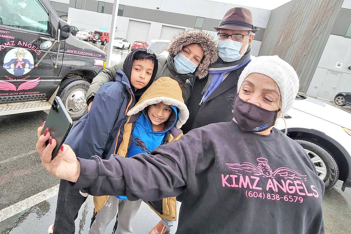Kim Snow, Kimz Angels founder, takes a selfie with Dr. Gulzar Cheema, his wife Harinder and their two grandsons after they dropped off donations on Saturday, Dec. 11, the first day of a two day fill-the-ambulance drive-thru donation drive in Langley. (Dan Ferguson/Langley Advance Times)