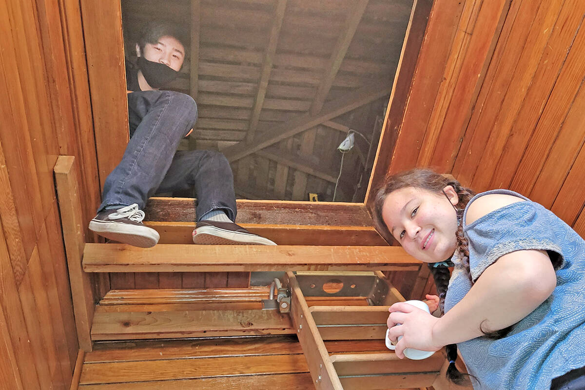 Aldergrove Community Secondary School students Jacky Guyho (left) and Iris Okazaki were sorting through historic artifacts in the attic of the Alder Grove Heritage Society museum at 3190 271 St. on Sunday, March 13. (Dan Ferguson/Langley Advance Times)