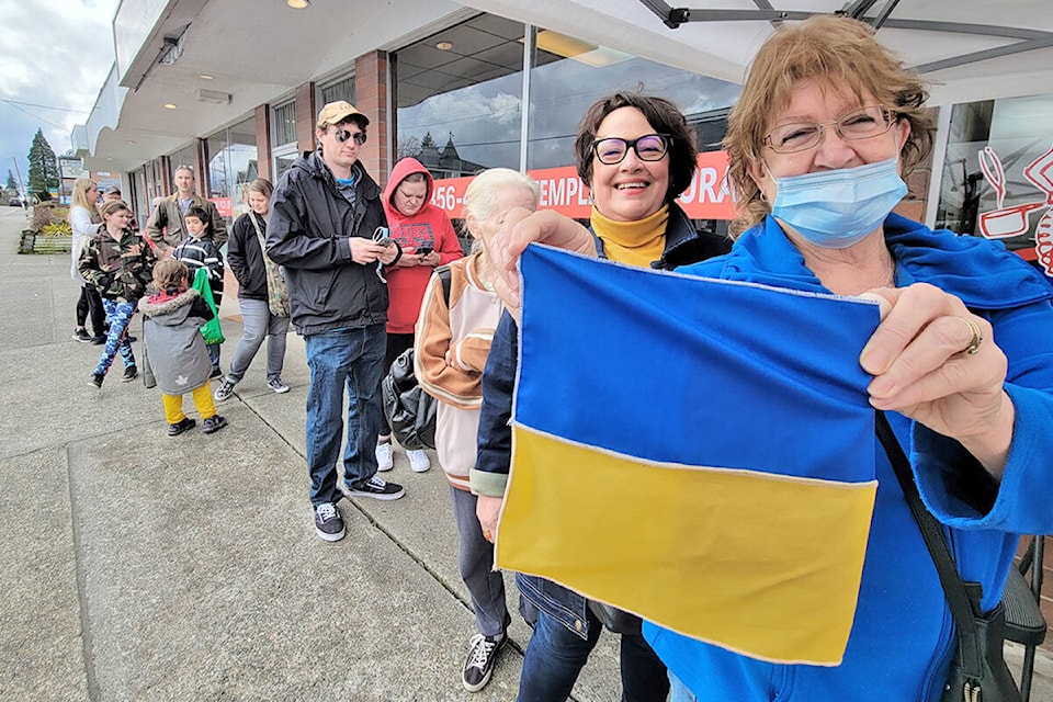 A Ukraine flag was displayed by a supporter waiting in line at Veronica’s Gourmet Perogies on Saturday, March 19. Owner Veronica Cave raised funds for the besieged country by selling deep fried apple cinnamon perogies. (Dan Ferguson/Langley Advance Times)