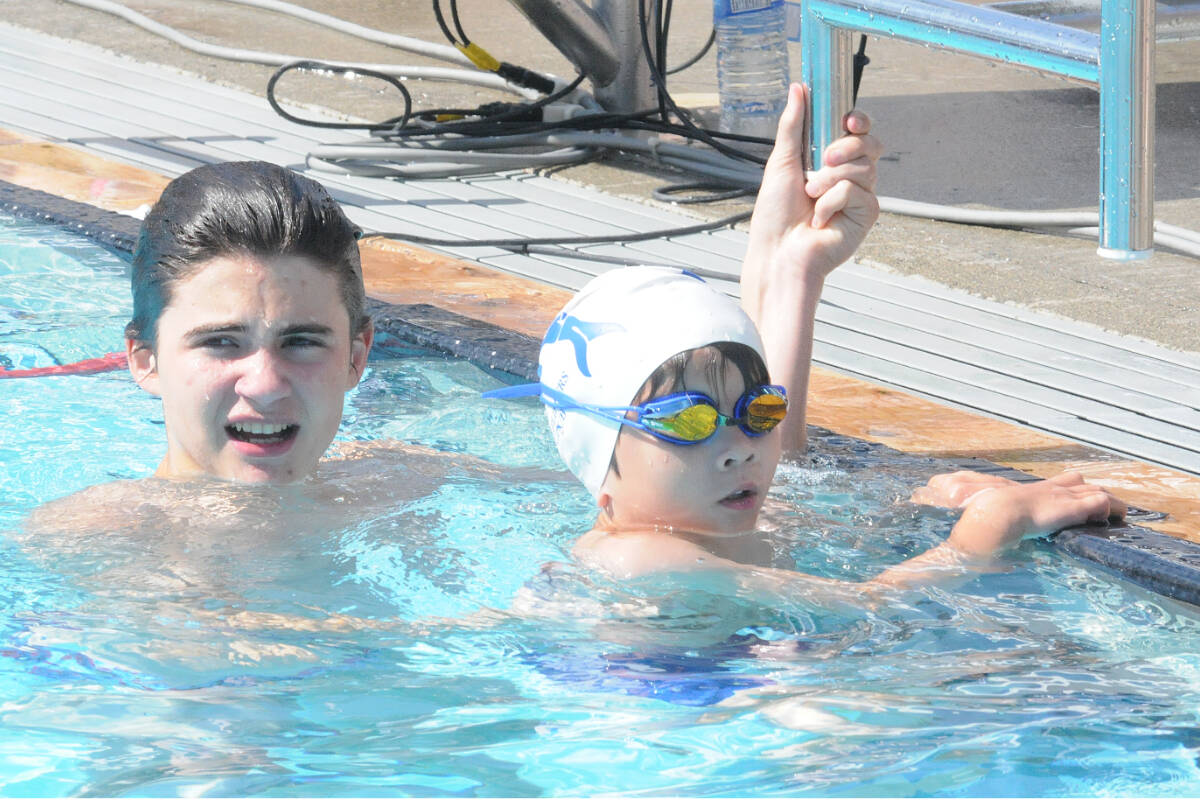 Mathew Schwalme was one of several swimming buddies who helped beginners like Bodhi Pettifer take part in the Langley Flippers Swim Club annual invitational, held July 2-3 at Al Anderson Poo. (Dan Ferguson/Langley Advance Times)