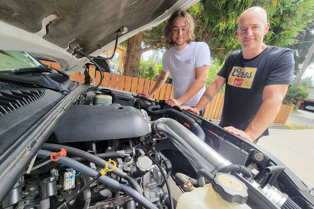 Brodie Johnstone (left) and dad Mark, long-time Cruise-In fans, have just completed their first custom vehicle project, swapping a stock V6 for a modified V8 in Brodies 1999 GMC Sierra 1500. (Dan Ferguson/Langley Advance Times)
