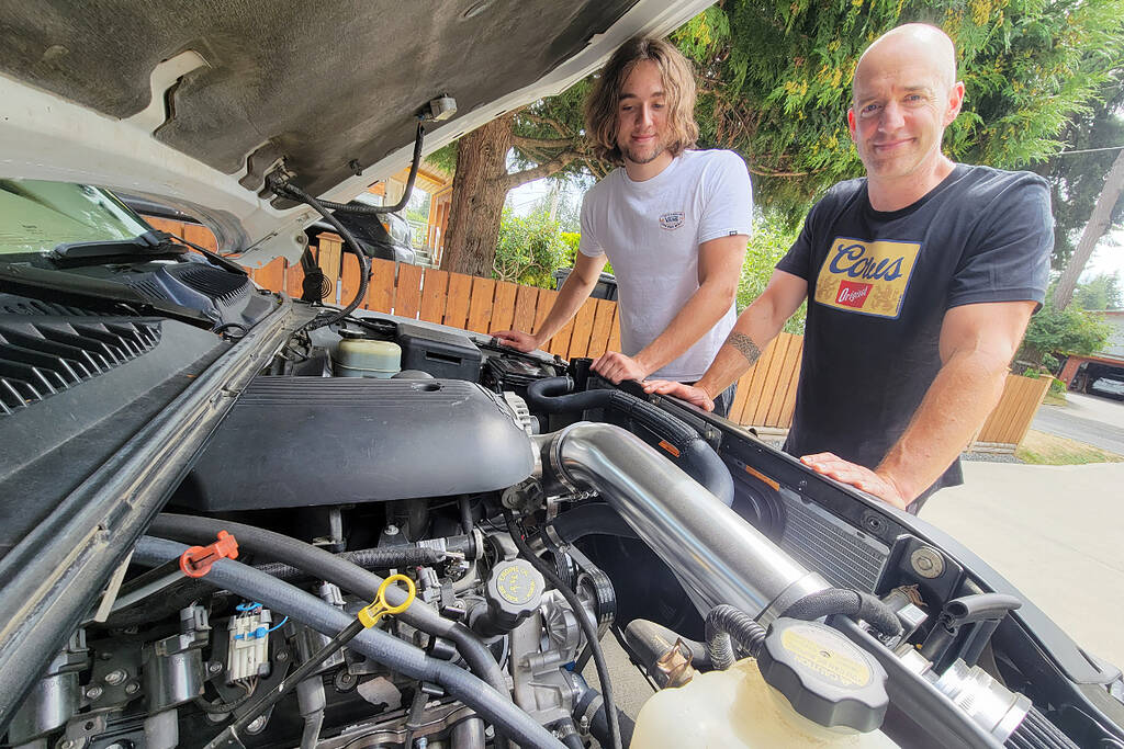 Brodie Johnstone (left) and dad Mark, long-time Cruise-In fans, have just completed their first custom vehicle project, swapping a stock V6 for a modified V8 in Brodies 1999 GMC Sierra 1500. (Dan Ferguson/Langley Advance Times)
