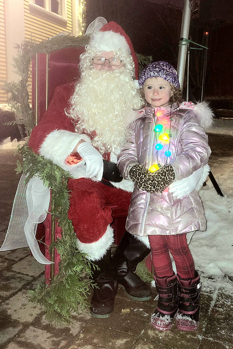 A young fan with her own lights had her picture taken with Santa at the annual tree lighting at the historic Fort Langley community hall on Saturday, Dec. 3. (Dan Ferguson/Langley Advance Times)