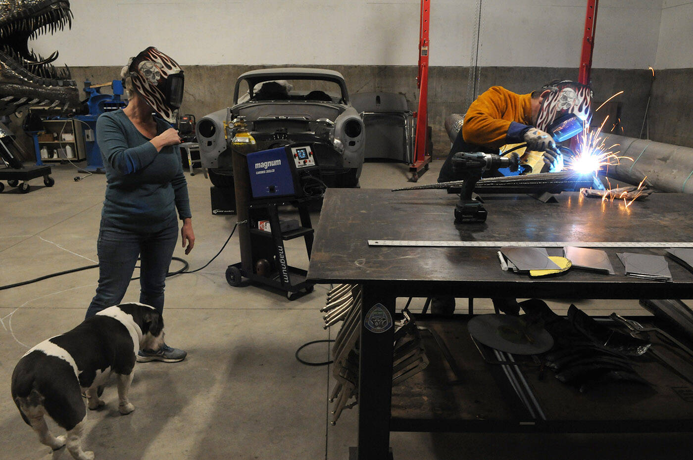 Michelle Stone watches as husband Kevin welds a piece of metal on Nov. 5, 2021. (Jenna Hauck/ Chilliwack Progress)