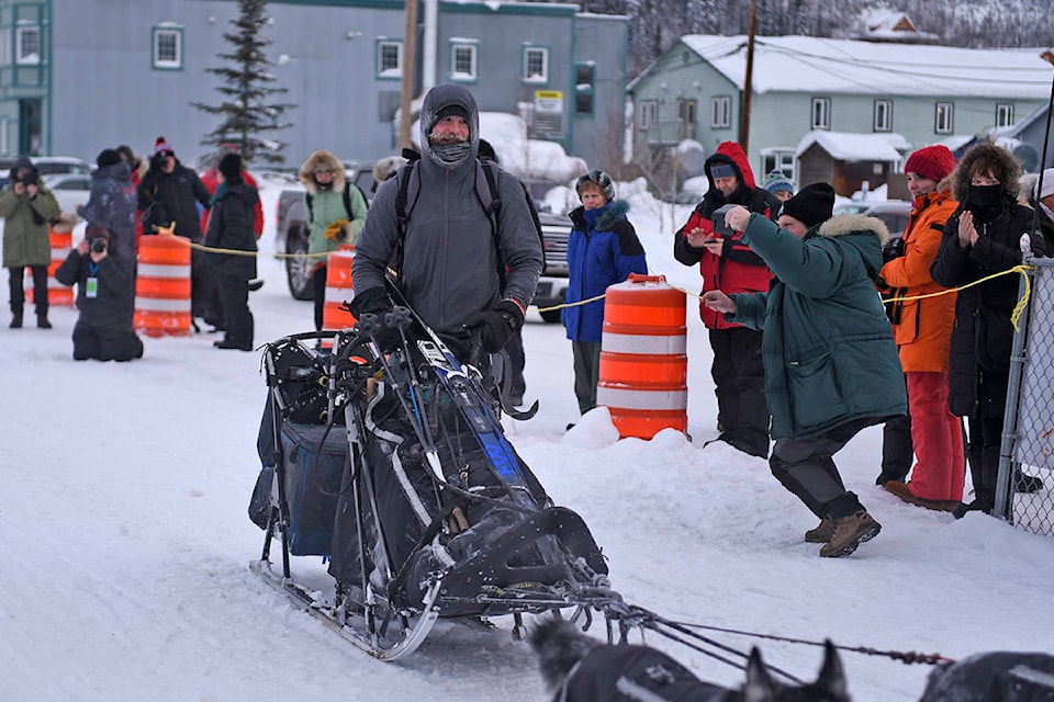 A man named Jason arrives at the Dawson checkpoint on Richie Beattie’s sled after he found the team running alone near Moosehide on Feb. 7. (John Hopkins-Hill/Yukon News)
