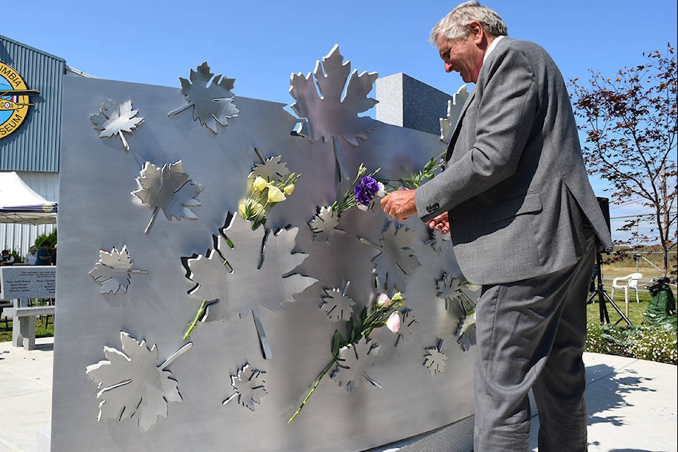 Memorial designer Illarion Gallant places roses on Lt. Robert Gray’s memorial. (Kiernan Green/News Staff)
