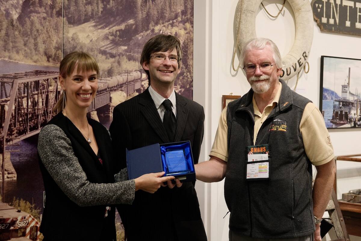 Tom Carr of Maple Ridge (right) representing the Great Northern Railway Historical Society, presents a plaque of appreciation to Touchstones Museum executive director Astrid Heyerdahl (left) and J.P. Stienne, the curator of the Back on Track exhibit. Photo: Bill Metcalfe