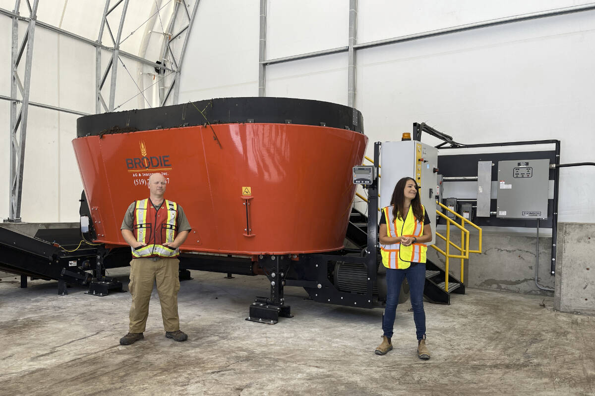 Two Regional District of Central Kootenay employees show off a large industrial mixer used to make compost. Photo: Tyler Harper